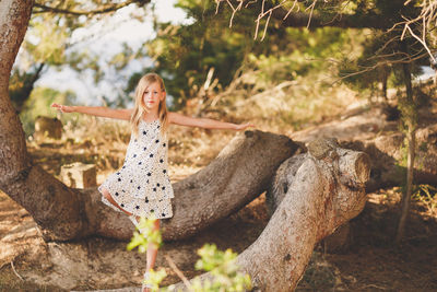 Portrait of girl standing on tree