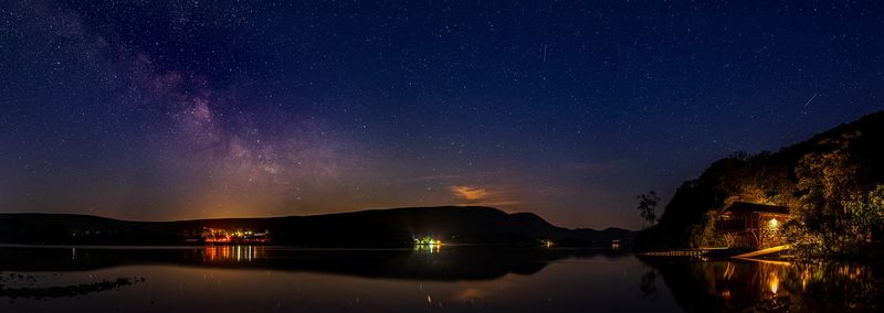 Scenic view of lake against sky at night