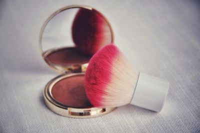 Close-up of make-up brush on blush on table