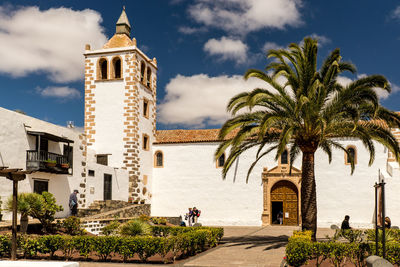 Palm trees and historical buildings against sky, fuerteventura 