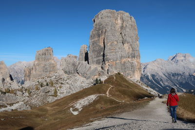 Rear view of man on rock against sky