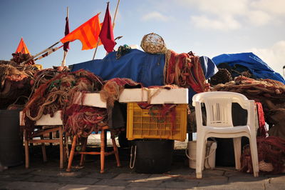 Fishing nets with chairs and crate at harbor