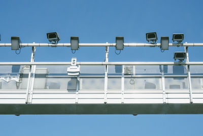 Low angle view of lights against clear blue sky