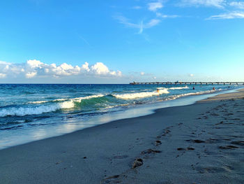 Scenic view of beach against blue sky