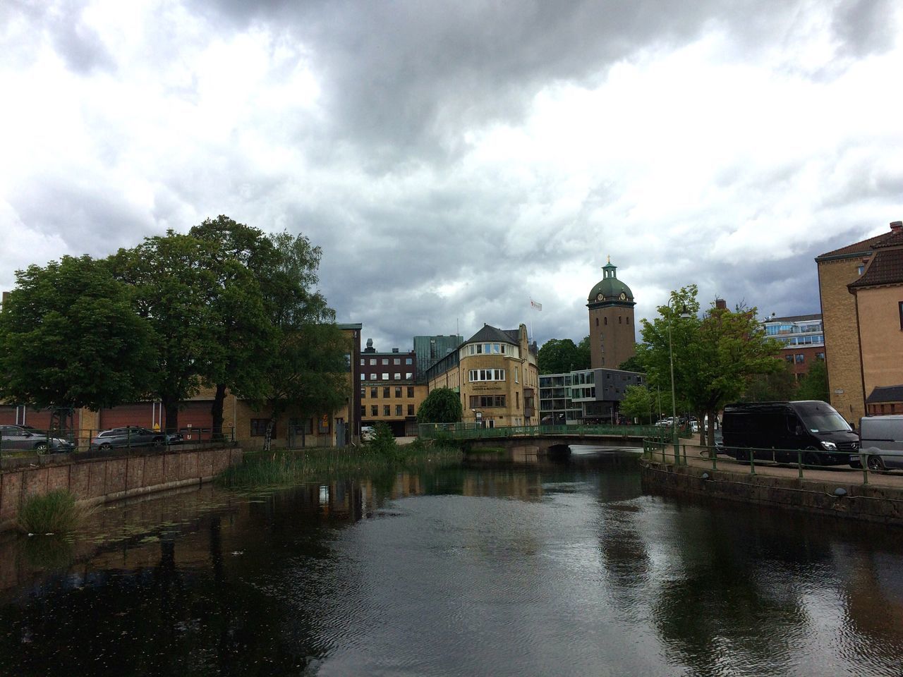 RIVER BY BUILDINGS AGAINST SKY