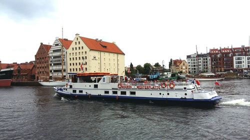 Boats in river with buildings in background