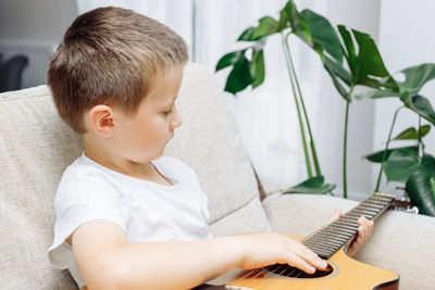 Boy playing guitar at home