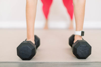 Low section of woman with dumbbell in gym