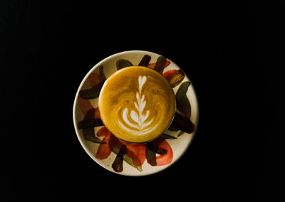 Directly above shot of coffee cup against black background