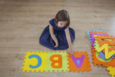 High angle view of girl with toy on floor