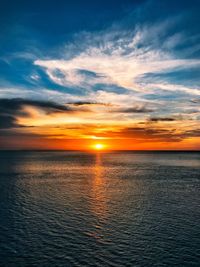 Scenic view of sea against dramatic sky during sunset