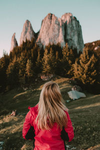 Rear view of woman standing on mountain against clear sky