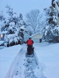 Rear view of woman walking on snow covered landscape