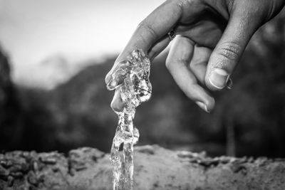 Close-up of hand holding water against blurred background