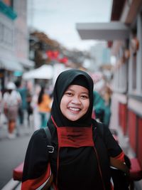 Portrait of a smiling young woman in city