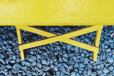 High angle view of yellow sign board on stones