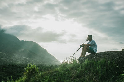 Man photographing on grass against sky