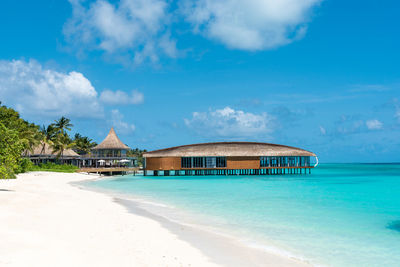 Built structures on beach against blue sky