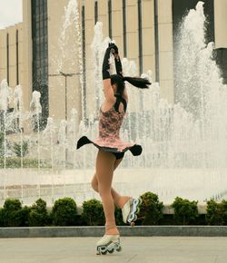 Full length of woman dancing in city