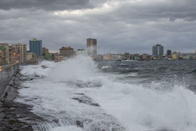 Scenic view of sea by buildings against sky