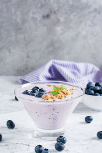 Smoothies with blueberries and granola in a bowl on the table. organic antioxidant healthy food. 