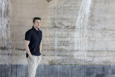 Young man leaning against wall