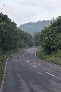 Road amidst trees against sky