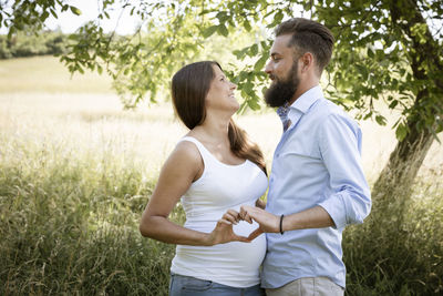 Side view of couple sitting on field