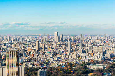 Aerial view of cityscape against blue sky