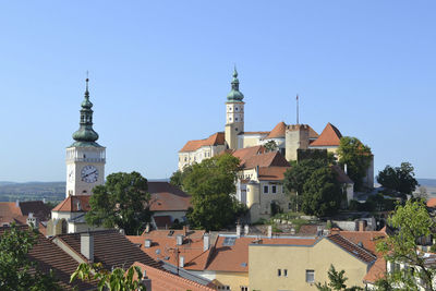 Buildings in city against clear sky