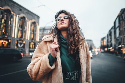 Young woman standing on street in city