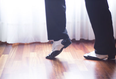 Low section of man dancing on floor at home