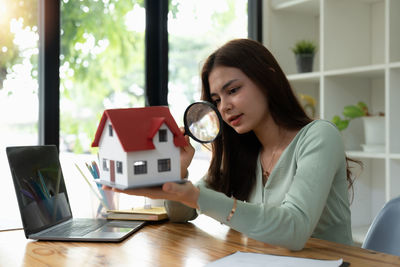 Portrait of young woman using laptop at home