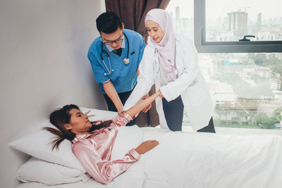 Young couple standing on bed