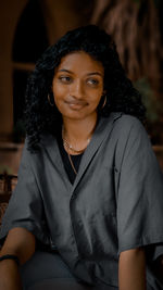 Portrait of a smiling young woman sitting outdoors