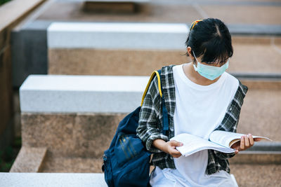 Full length of woman sitting on book