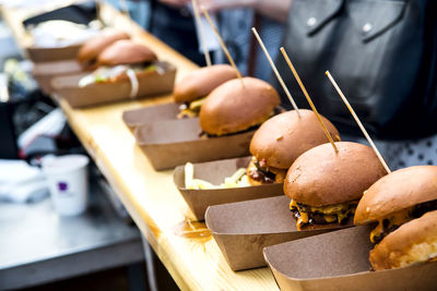 Street food many burgers with meat and cheese and french fries in craft packaging. 