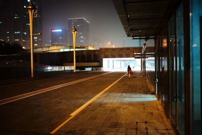 Man walking on illuminated street at night