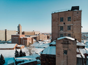 Buildings in city against clear blue sky