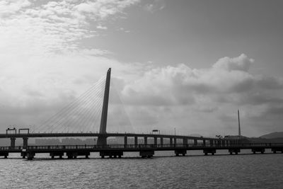 Bridge over calm sea against sky