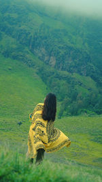 Rear view of woman standing on mountain