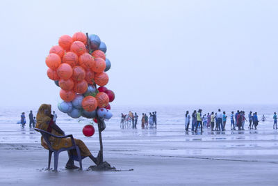 People on beach against clear sky