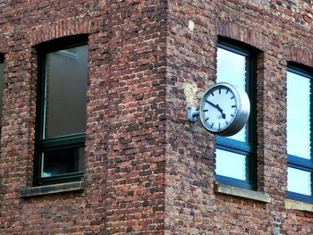 Low angle view of clock on brick wall