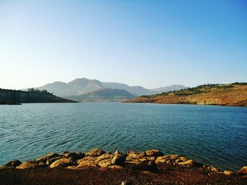 Scenic view of lake in front of mountains against clear sky