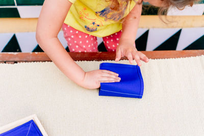 Midsection of woman using digital tablet on table