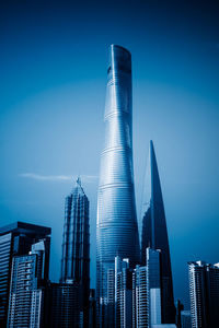 Low angle view of modern buildings against blue sky