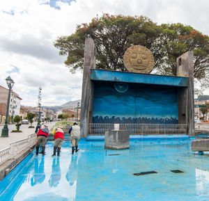 People by swimming pool against sky