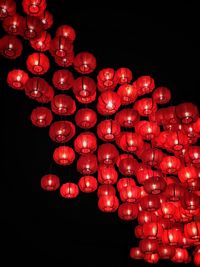 Low angle view of illuminated lanterns over black background