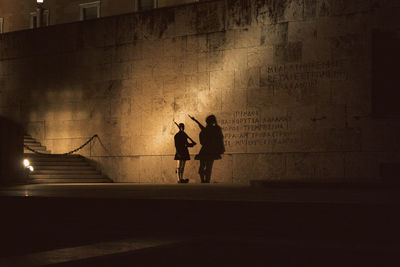 Evzone standing by greek parliament building at night