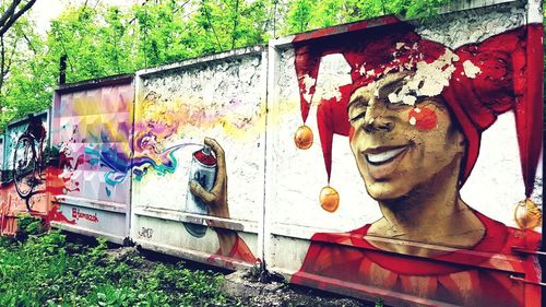 Portrait of man standing against graffiti wall